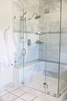 a walk in shower sitting next to a white towel