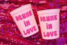 two plastic cups that say drunk in love and drink in love on pink sequins