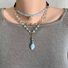 Add a touch of boho elegance to your everyday look with this wonderful Sundance Style gemstone layered necklace.   This captivating piece features a harmonious blend of aquamarine, rutilated quartz and a touch of apatite gemstones. The delicate layers of shimmering beads create a mesmerizing visual display.   The adjustable genuine leather cord ensures a comfortable and customizable fit, while the delicate gold-plated accents add a touch of luxurious sophistication. Let this magnificent necklace become your go to accessory or give it as a unique gift to someone special. It will arrive in a ribboned box and is carefully packaged in another box for shipping. Thank you for viewing and, if you have time, please browse through AERJewelryDesign. www.aerjewelrydesign.etsy.com Beads 4x 2mm, 6mm, 3 Gemstone Necklace Diy, Pyrite Pendant, Beaded Stuff, Sundance Style, Visual Display, Pretty Jewelry, Labradorite Beads, Labradorite Necklaces, Layered Necklace