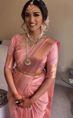 a woman in a pink sari and gold jewelry