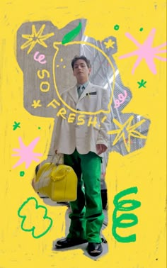 a man standing in front of a yellow background holding a handbag and wearing green pants