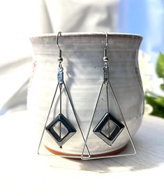 These fun earrings are made with a silver plated triangle and a hematite diamond shape that dangles from the top of the triangle. They dangle about two inches from the stainless steel ear wire. Modern Silver Triangle Earrings, Nickel Free Triangle Metal Earrings, Nickel-free Metal Triangle Earrings, Silver Triangle Jewelry With Ear Wire, Earring Frame, Earrings Triangle, The Triangle, Triangle Earrings, Geometric Earrings