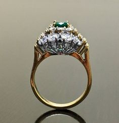 DeKara Designs Classic Handmade Art Deco Oval Emerald and Diamond Ring. Metal- 18K Yellow Gold, .750 Stones- 1 Oval Natural Green Colombian Emerald 0.81 carats, 22 Round Diamonds, 10 Baguette Diamonds, F-G Color VS2 Clarity 2.85 Carats. Art Deco inspired 18K Yellow Gold Diamond Colombian Emerald Engagement Ring. The ring features a beautiful green Colombian Emerald, that is truly an exceptional color and quality. There are five baguette diamonds on each side of the emerald that are prong set, an Luxury Gold Emerald Ring With Halo Setting, Classic Gold Emerald Wedding Ring, Heirloom Yellow Gold Emerald Ring With Center Stone, Classic Gold Emerald Ring With Halo Setting, Luxury Emerald Ring With Prong Setting For Wedding, Gold Emerald Cluster Ring With Brilliant Cut, Exquisite Yellow Gold Cluster Diamond Ring, Exquisite Yellow Gold Cluster Ring For Formal Occasions, Elegant Gold Emerald Ring For Wedding