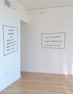 an empty room with two drawings on the wall