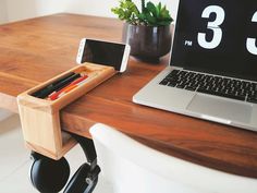 a desk with a laptop, phone and pen holder sitting on it's side