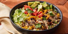 a black bowl filled with taco salad and avocado