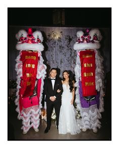 a bride and groom standing in front of chinese decorations