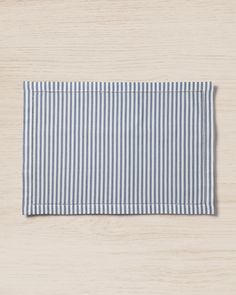 a blue and white striped placemat on a wooden surface