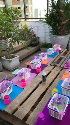 an outdoor picnic table is set up with plastic containers and cups on top of it