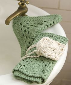 a green crocheted blanket sitting on top of a white toilet