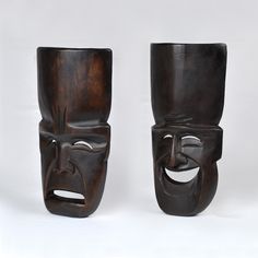 two wooden masks with faces painted on them