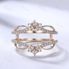 two gold rings with diamonds on them sitting next to each other in front of a white background