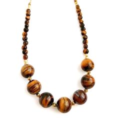 Very pretty golden Tiger's eye necklace. Large round Tiger's eye stone beads that measure about   inches with accent gold metal beads in between, & faceted Tiger's eye stone beads along the ends. This necklace measures about 23.75 inches in length & can be shortened if desired. (Please see the different length options for this necklace). Natural colors & swirl patterns in these stone beads. Shades of gold & brown, perfect for Fall! Gold Crystal Necklace With Large Round Beads, Brown Faceted Bead Necklaces, Brown Faceted Round Bead Necklaces, Gold Natural Stones Round Beads, Gold Round Beads With Natural Stones, Stone Beads Necklace, Golden Tiger, Semiprecious Stone Jewelry, Tigers Eye Necklace