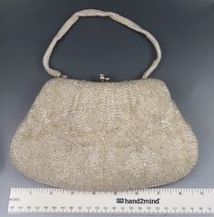 Presented is an antique/vintage needlepoint bead work purse or hand bag made in Japan around the early to mid 1900s. The whole piece is intricately hand stitched with swirling, silver bead-work over a white cloth. The silver tone metal, clutch style clasp at the top is secure. The silk-lined inside has 1 small pouch section and also includes a change purse, mirror and 2 small envelope style pouches. This piece is in excellent condition for its age. There are no missing parts, no damages and no r Vintage Evening Bag With Handwork For Formal Occasions, Vintage Handwork Evening Bag For Wedding, Vintage Wedding Evening Bag With Handwork, Vintage Rectangular Bag With Pearl Embroidery, Vintage Formal Bag With Pearl Embroidery, Vintage Formal Bags With Pearl Embroidery, Purse Mirror, Work Purse, Small Envelope