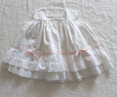 "FRENCH VINTAGE 50's, stunning white summer dress, pure cotton fabric, French lace ruffles and pink satin ribbon, buttoned at the back ( mother of pearl buttons ).  Estimated size 1 year Length \" - Underarams ( taken flat ) \" New old stock ( washed once ) I always refund overcharged shipping from 1 Euros overpaid ! Thank you for your visit" White Fitted Ruffled Vintage Dress, Fitted White Vintage Dress With Ruffles, White Fitted Vintage Dress With Ruffles, Summer Cotton Lace Dresses With Ruffles, Summer Dress With Cotton Lace Collar, White Lace Dress With Broderie Anglaise, Feminine Cotton Dresses With Broderie Anglaise, Spring Sleeveless Ruffled Petticoat, Summer Cotton Petticoat With Ruffles