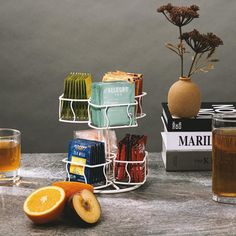 an assortment of teas, orange slices and other items on a table next to some books