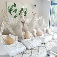 a room filled with lots of pillows and teepees