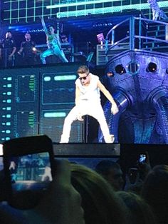 a man standing on top of a stage in front of a crowd