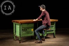 a man is sitting at a green desk