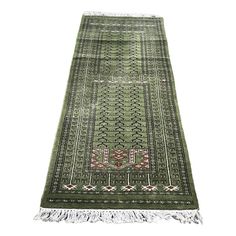 a green rug with fringes on the bottom and an intricate design in the middle