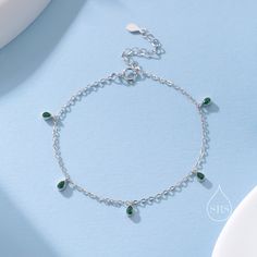 Emerald Green CZ Droplet Bracelet in Sterling Silver, Silver or Gold, Silver Blue CZ Pear Cut Bezel Bracelet, CZ Cluster Bracelet Dimension:  Chain length: 15cm plus 3cm extension chain.   Production method:  Small Batch Lost-wax casting. Stamp: 925 SRS ( Our brand initials for Silver Rain Silver).  Materials and Care: These are made with solid sterling silver and coated with precious metal Rhodium and with the option of 18ct yellow gold. When not wearing, please keep in a sealed plastic bag.  P Formal Silver Bracelet With Emerald, Silver Emerald Bracelet Jewelry, Formal Silver Emerald Bracelet, Silver Emerald Bracelet, Silver Emerald Gemstone Bracelet, Adjustable Green Crystal Metal Bracelet, Cluster Bracelet, Bezel Bracelet, Cluster Bracelets