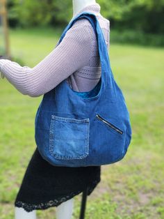 Large, soft, lined denim hobo bag with 3 pockets and nice wide straps.  This large bag is made with upcycled denim and is lined with a cotton fabric in a teal color with small black flowers on it.  There is one large zippered pocket on the inside, along with a hoop to hook your keys onto.  There are two pockets on the outside, one of which is a large zippered pocket.  The straps are 25 inches long and the bag is 20 inches wide by 15 inches deep (all measurements are approximate). Cheap Casual Denim Hobo Bag, Cheap Denim Blue Hobo Bag For Daily Use, Cheap Blue Hobo Bag With Pockets, Cheap Denim Blue Hobo Bag For Women, Hobo Bag From Old Jeans Free Pattern, Cheap Blue Denim Hobo Bag, Cheap Denim Hobo Tote Bag, Cheap Blue Hobo Bag With Handles, Denim Hobo Bag