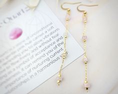 The WonderLight Gemstone Chain Earrings feature stainless steel hooks that holds a single 18k gold chain that is beaded with natural rose quartz gemstones. These are perfect for sensitive ears.  They bring both simplicity and elegance to any style. Rose Quartz is a powerful symbol of unconditional love. Its serves as a constant reminder to allow the vibrations of love to flow freely and fearlessly. Each pair of earrings comes with a coordinating affirmation card, with gemstone meaning on one sid Affirmation Jewelry, Dainty Gold Earrings, Gold Chain Earrings, Quartz Gemstones, 18k Gold Chain, Gemstone Meanings, Rose Quartz Gemstone, Earrings Long, Quartz Rose