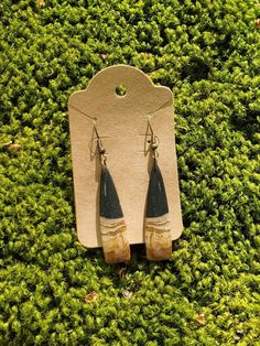 two pairs of earrings are sitting on some grass