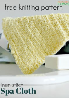 a yellow knitted cloth sitting on top of a white plate