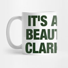 it's a beaut clari coffee mug with green lettering on the front