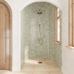 an arched doorway leads to a tiled shower