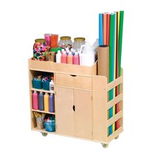 a wooden storage cart with lots of craft supplies on top of it, including pens and pencils