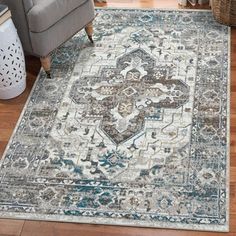 a large area rug with an ornate design on the floor in a living room setting