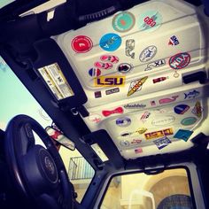 the interior of a vehicle with various stickers on it's side window and steering wheel