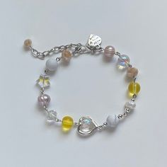 "A sweet bracelet. This colorful piece features: ✿ Made with freshwater pearls, glass crystal beads, metal accents, and an assortment of glass beads ✿ Pearlescent peach, iridescent clear, peach, yellow, and silver ✿ The bracelet has an additional 1-1.5\" of extension chain. Some beads may be added or removed depending on the length selected" Silver Pearl Beaded Bracelets With Colorful Beads, Silver Pearl Bracelets With Colorful Beads, Summer Bracelets, Metal Accents, Cute Bracelets, Heart Candy, Glass Crystal, Metallic Accents, Golden Hour