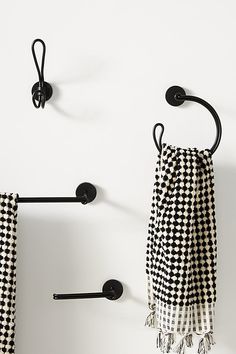 two black and white checkered towels hanging on the wall next to towel racks with hooks