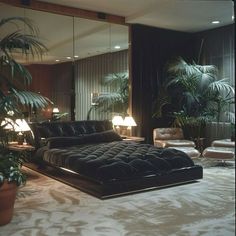 a large bed sitting in the middle of a living room next to a plant filled wall