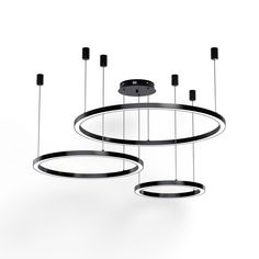 three circular lights hanging from the ceiling in front of a white background with black accents