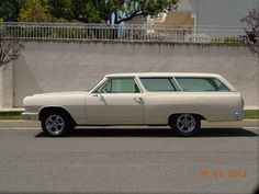 an old station wagon is parked on the side of the road