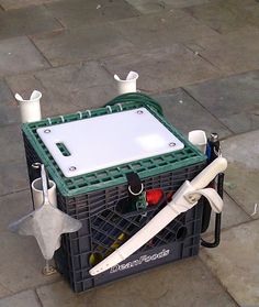 a wine crate sitting on the sidewalk with its contents in it