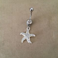 "Starfish Belly Button Ring - silver crystal belly ring, beach wedding jewelry, beach vacation, sea star, body jewelry, dangle belly ring Pretty belly ring in surgical steel with a double gem in clear and a rhinestone encrusted starfish with embossed detal   entire piece approx 1 5/8\" long. /42mm 14 gauge Large barbell rhinestone approx 7mm across - star pendant Approx 7/8 (24mm) long  Comes in an organza gift bag matching necklace available To keep the rhinestones looking their best I recommend you do not wear this piece while swimming or bathing. NOT RECOMMENDED FOR THOSE WITH SENSITIVE SKIN, METAL ALLERGIES, OR NEW PIERCINGS also in gold https://www.etsy.com/listing/206653692/belly-button-ringstarfish-bellybutton I DO NOT OFFER RETURNS or EXCHANGES, so please select carefully, thank yo Bellybutton Ring, Wedding Jewelry Crystal, Bellybutton Rings, Belly Button Piercing Jewelry, Beach Wedding Jewelry, Belly Piercing Jewelry, Belly Piercing Ring, Gold Belly Ring, Button Piercing