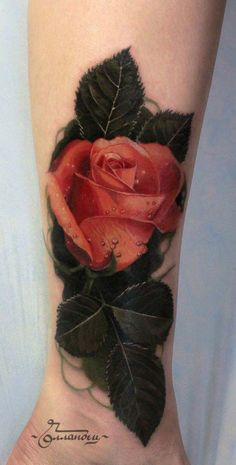 a rose tattoo on the foot of a woman's right leg, with leaves around it