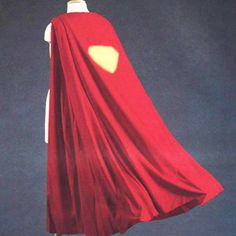 a red cape is shown on top of a mannequin's head and torso