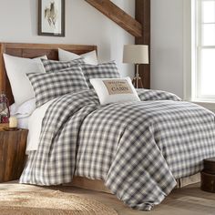 a bed with white and black checkered comforter set in a bedroom next to a window