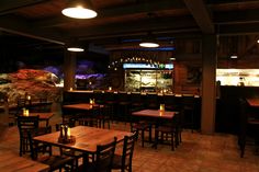 a dimly lit restaurant with wooden tables and chairs