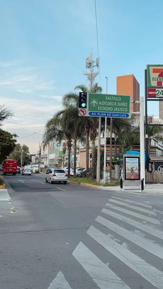 a traffic light sitting on the side of a road next to tall buildings and palm trees