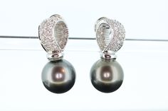 Wonderful and Lustrous Tahitian PEARL and Diamond Dangle Clip on  Earrings. 18k White Gold with In and Out Pave Diamonds. Conditions: Shows little to no wear. Tahitian pearls 11.8-11.9mm diameter. 62 diamonds totaling 0.59ctw. Range in VS to SI clarity F-E color. 11.04grams total. 26mm from top to bottom Omega Backs hold well Insurance appraised at $8510. Elegant Tahitian Pearl Earrings For Wedding, Luxury Silver Tahitian Pearl Earrings, Elegant White Gold Tahitian Pearl Earrings, Luxury Tahitian Pearl Wedding Earrings, Elegant Tahitian Pearl Earrings For Formal Occasions, Black Tahitian Pearls, Tahitian Pearl Earrings, Tahitian Black Pearls, Tahitian Pearls