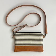 This small crossbody bag for women is compact & lightweight while still offering plenty of room to carry essential items like your cash & bank cards, phone, and keys while you run errands or go out with friends. It's perfect for women who love a small bag, but also want to be hands-free. Use it as an every day handbag or travel bag and enjoy the ease of an adjustable strap that enables you to wear it crossbody or over-the-shoulder.  SIZE:  9" wide x 6" high, crossbody strap is adjustable up to 50" long Features -  * exterior is made with designer cotton canvas in black & ivory ticking stripe and caramel brown vegan leather  * interfaced to give it structure and durability * detachable crossbody strap in matching vegan leather * interior lining is made using coordinating cotton in black  * Ticking Stripe, Leather Crossbody Purse, Mom Gifts, Small Crossbody Bag, Small Crossbody, Small Shoulder Bag, Bag For Women, Crossbody Purse, Handmade Bags