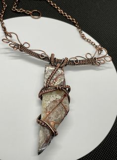 Make a bold statement with this Crazy Lace Agate Necklace, featuring a stunning piece of crazy lace agate set in intricate wire-wrapped copper. The unique patterns and vibrant colors of the agate are beautifully highlighted by the handcrafted copper setting, creating a striking and elegant necklace. An original Monkeylion Design. Main Copper component is approximately 3 1/4" wide and 4 1/4" long - hanging from a copper chain. This necklace has been antiqued, polished and sealed. Sealed with Prot Elegant Necklace, Agate Necklace, Copper Chain, Crazy Lace Agate, Elegant Necklaces, Lace Agate, Unique Patterns, Wire Wrapped, Agate