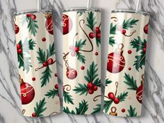 three christmas themed tumblers sitting on top of a marble counter